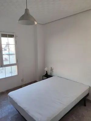 a large white bed in a room with a window at Carmen & Alejandro Home in Valencia