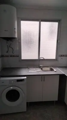 a kitchen with a sink and a washing machine at Carmen & Alejandro Home in Valencia