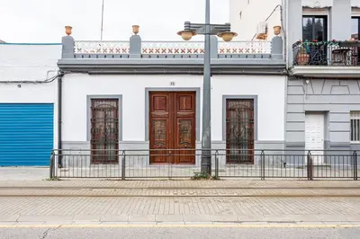 a white building with brown doors on a street at GuestReady - Traditional House near Malvarrosa in Valencia