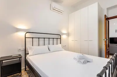a bedroom with a large bed with white sheets at GuestReady - Traditional House near Malvarrosa in Valencia