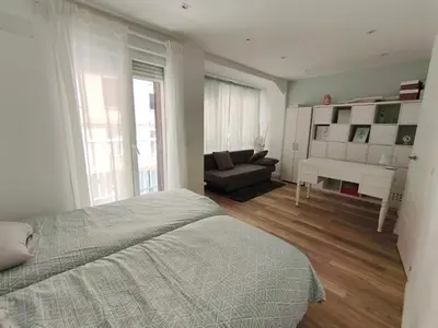 a bedroom with a bed and a living room with a couch at Valencia City Premium Terrace Apartment in Valencia