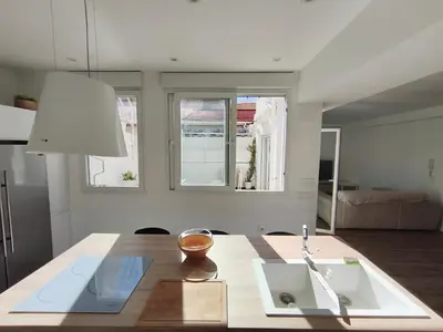 a kitchen with a table with a sink and two windows at Valencia City Premium Terrace Apartment in Valencia