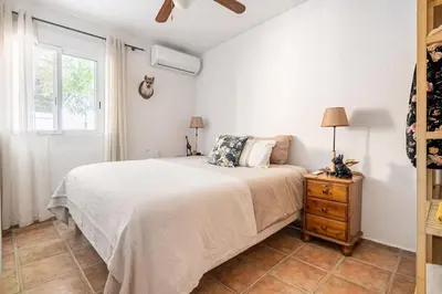 a white bedroom with a bed and a window at Tiny House Long-term en remote work near Valencia in Torrent
