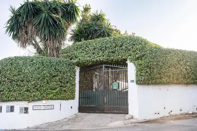 a gate in a white building with ivy at Tiny House Long-term en remote work near Valencia in Torrent