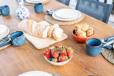 a table with strawberries and croissants and a bowl of fruit at Tiny House Long-term en remote work near Valencia in Torrent