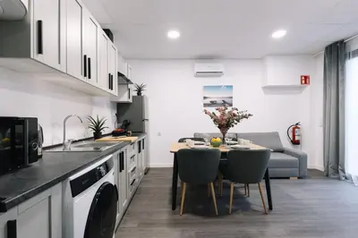 a kitchen and dining room with a table and chairs at Modern Stay Near Benicalap Park in Valencia