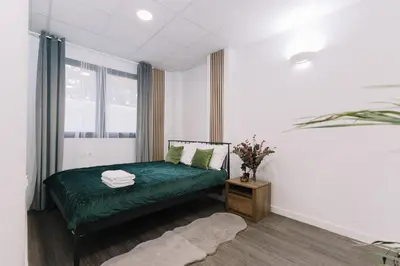 a bedroom with a green bed and a window at Modern Stay Near Benicalap Park in Valencia