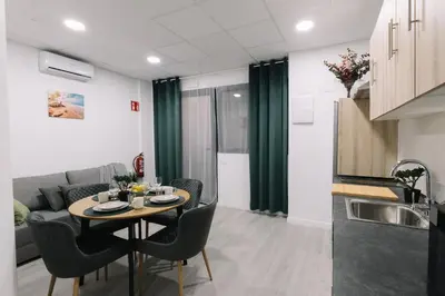 a kitchen and a living room with a table and chairs at Modern Stay Near Benicalap Park in Valencia