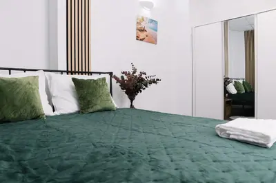 a bedroom with a bed with a green comforter at Modern Stay Near Benicalap Park in Valencia