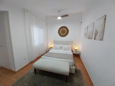 two beds in a white room with two lamps at Chalet adosado junto al mar en Almarda Sagunto in Almarda