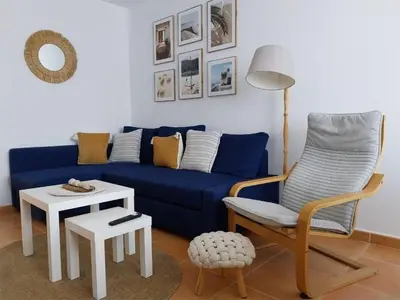 a living room with a blue couch and a table at Chalet adosado junto al mar en Almarda Sagunto in Almarda