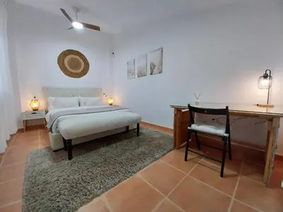 a bedroom with a bed and a table and a desk at Chalet adosado junto al mar en Almarda Sagunto in Almarda