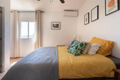 a bedroom with a bed with yellow sheets and a window at Casa Rosa Longterm Living and Workspace in Monserrat
