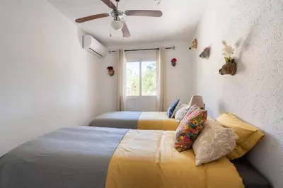 a bedroom with two beds and a ceiling fan at Casa Rosa Longterm Living and Workspace in Monserrat