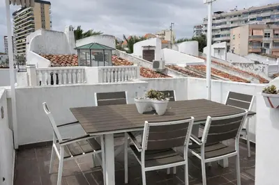 a wooden table and chairs on a balcony at Terraced House MARIELISA in Puebla de Farnals