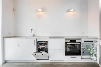 a white kitchen with white cabinets and appliances at Casa Reina Nina in Valencia