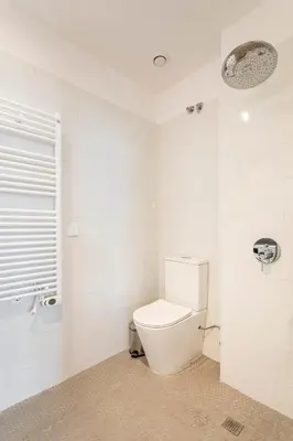 a white bathroom with a toilet and a window at Casa Reina Nina in Valencia