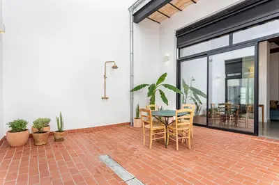 a patio with a table and chairs on a brick floor at Casa Reina Nina in Valencia