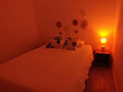two pillows with tropical leaves on a bed at SeaSuites Blue - Casa cerca del mar en Cullera in Mareny de San Lorenzo