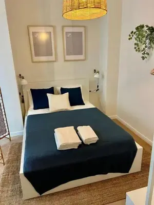 a bedroom with a blue bed with two towels on it at Aqua Vida Apartments Sueca in Sueca
