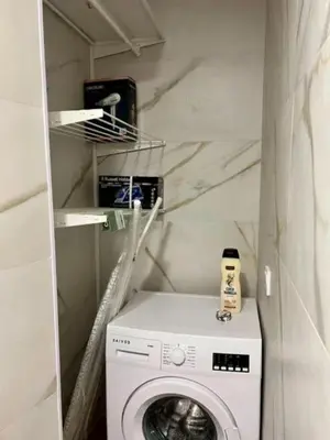 a laundry room with a washing machine and shelves at Aqua Vida Apartments Sueca in Sueca