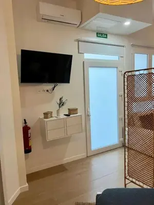 a living room with a door with a television on the wall at Aqua Vida Apartments Sueca in Sueca