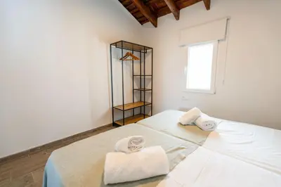 a white bedroom with towels on a bed at Pinedo Playa Rustico in Valencia