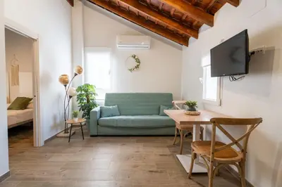 a living room with a green couch and a table at Pinedo Playa Rustico in Valencia