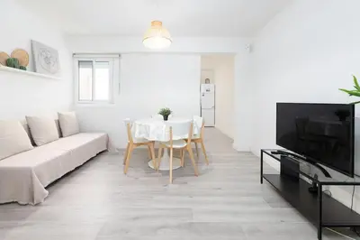 a white living room with a table and a couch at Mislata Apartment in Valencia