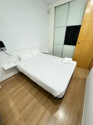 a white bed in a room with a mirror at Heart of Valencia in Valencia