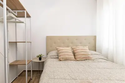 a bedroom with a bed with a white wall at Cielito Lindo Tu hogar temporal con encanto in Torrent
