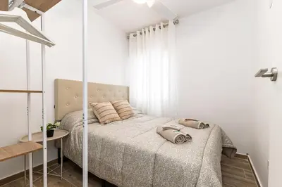 a white bedroom with a bed and a window at Cielito Lindo Tu hogar temporal con encanto in Torrent