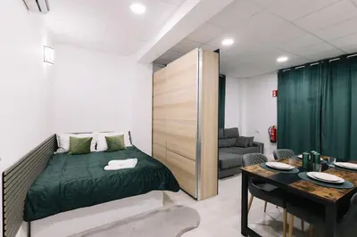 a bedroom with a bed and a couch and a table at N4 Comfortable & bright apartament Park Benicalap in Valencia