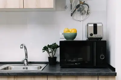 a kitchen counter with a microwave and a sink at N4 Comfortable & bright apartament Park Benicalap in Valencia