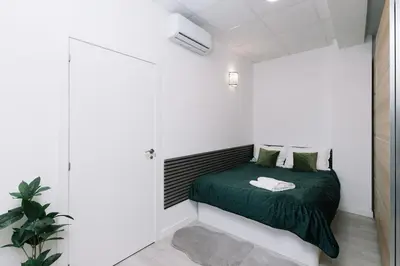 a small bedroom with a green bed and a shower at N4 Comfortable & bright apartament Park Benicalap in Valencia