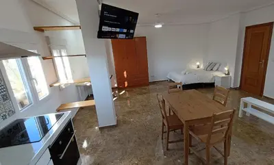 a living room with a table and a bed at Magnifico y moderno estudio bien ubicado in Valencia