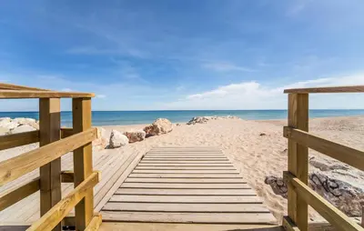 a wooden boardwalk leading to the beach at Lovely Apartment In Tavernes De La Valldig in Tavernes de Valldigna