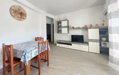 a dining room with a table and a clock on the wall at Lovely Apartment In Tavernes De La Valldig in Tavernes de Valldigna
