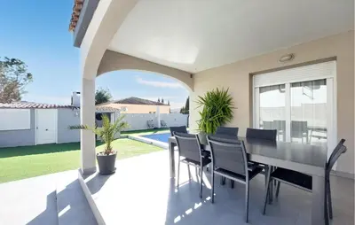 a dining room with a table and chairs on a patio at Awesome Home In Olocau in Olocau