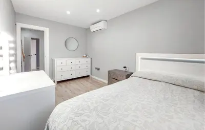 a white bedroom with a bed and a dresser at Awesome Home In Olocau in Olocau