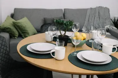 a wooden table with plates and wine glasses on it at N2 Bright & Comfortable Apartment Benicalap in Valencia