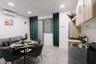 a living room with a table and a kitchen at N2 Bright & Comfortable Apartment Benicalap in Valencia