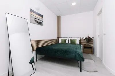 a bedroom with a green bed and a mirror at N3 Bright and Cosy apartament Park Benicalap N3 in Valencia