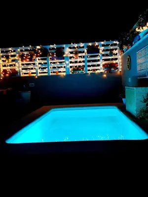 a swimming pool on a balcony at night at Acogedor y exótico hogar con piscina privada in Rafelguaraf