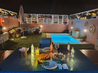 a table with food on it next to a pool at Acogedor y exótico hogar con piscina privada in Rafelguaraf