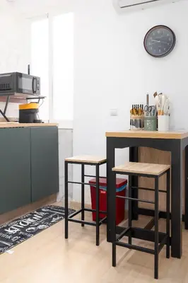 a kitchen with two stools and a table in a kitchen at Modern 2BR in Beautiful Burriana in Burriana