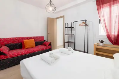 a living room with two beds and a red couch at Modern 2BR in Beautiful Burriana in Burriana