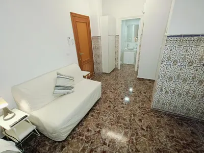 a room with a white bed and a bathroom at Espectacular estudio en PB con terraza privada in Valencia