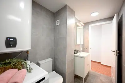 a bathroom with a white toilet and a sink at Vistas al Mar in Puerto de Sagunto