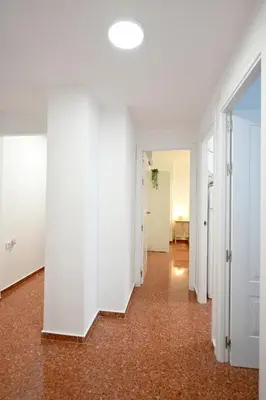 an empty hallway with white walls and red carpet at Vistas al Mar in Puerto de Sagunto